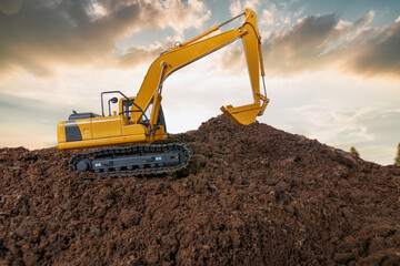 Crawler excavator is digging soil in the construction site   with sunset  backgrounds.