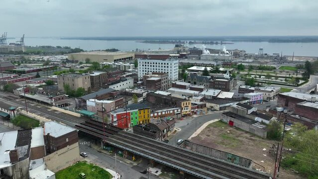 Downtown Chester, Pennsylvania. Aerial establishing shot of crime-ridden suburb of Philadelphia. Kimberly Clark manufacturing plant and Delaware River in distance. SEPTA commuter train tracks.