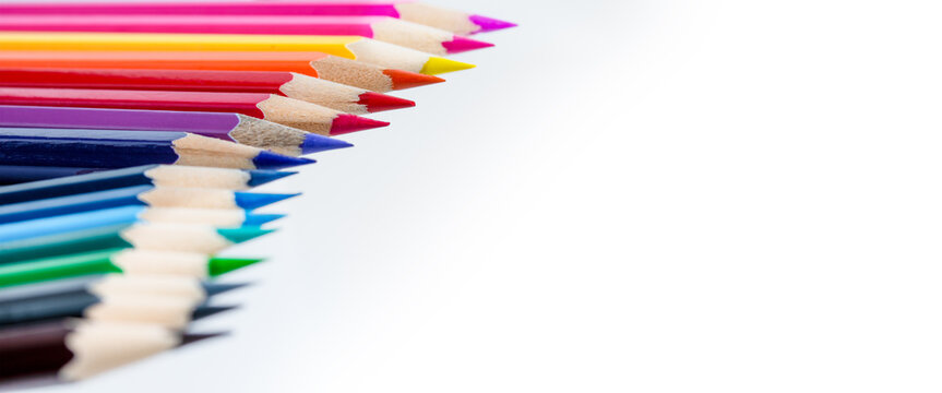A row of colored pencils against a white background, designed to be used as border for page layout, with space for text.