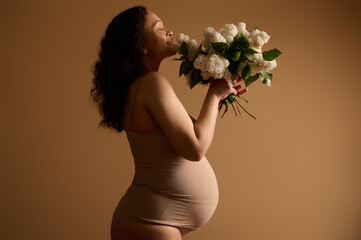 Side beauty portrait multi ethnic pretty pregnant gravid woman, expectant mother with big belly in...