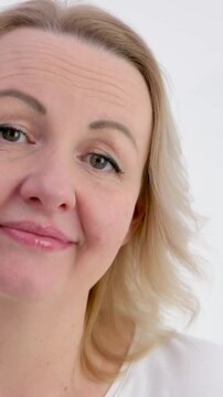 shake head no no shrug blonde woman on white background middle aged dissatisfied with something disappointed at same time smiling tenderly showing well 