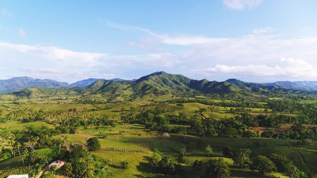 Summer morning landscape of the nature of the Dominican Republic from a bird's eye view. Ecological air travel to mountain peaks background stock video. Blue cloudy sky over green hills.