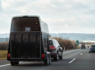Road Trip with Equine Companion. Horse Trailer Journey Across Europe. Car with a horse trailer on the road in Europe. Horse transport on the motorway. © AlexGo