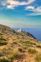 Fototapeta na wymiar The beautiful lighthouse on the cliff of Cap Formentor. Balearic Islands Mallorca Spain. Vacation concept. One of the most visited landmark in Mallorca