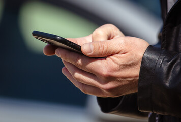 Smartphone in the hands of a man in nature. Close-up.