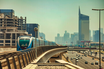 Train on monorail of Dubai modern subway at urban skyscrapers background. Wallpaper of city...