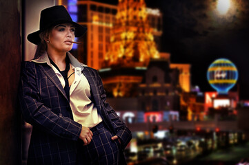 Woman in a suit with a cigarette against the background of the city at night