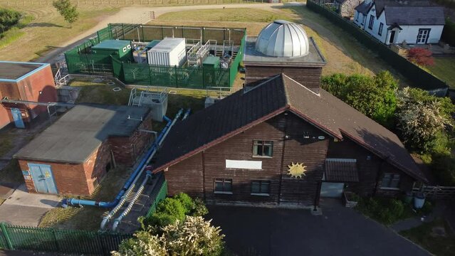 Aerial view Pex hill Leighton observatory silver dome rooftop on hilltop farmland at sunrise, low orbit left