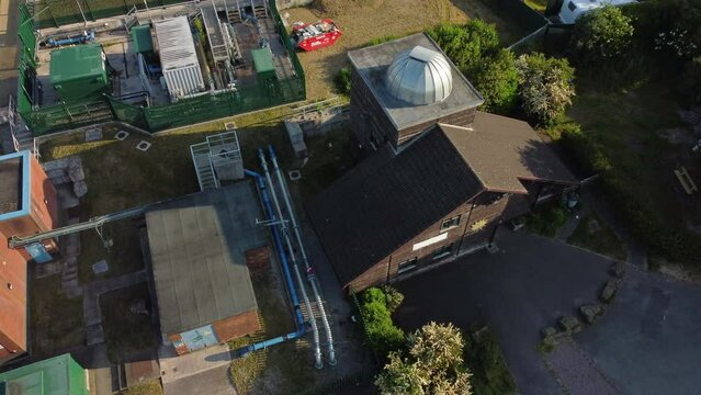Aerial rising view looking down over Pex hill Leighton observatory silver dome rooftop on hilltop farmland at sunrise