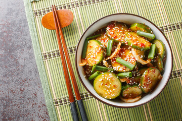 Easy Spicy Korean Cucumber Salad Oi Muchim made with garlic, onion, sesame and hot peppers on the table. Horizontal top view from above