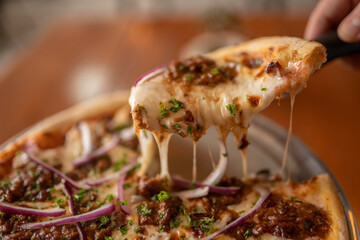 Delicious Thin Crust Pizza with Melty Cheese, Beef Barbacoa, and Red Onion
