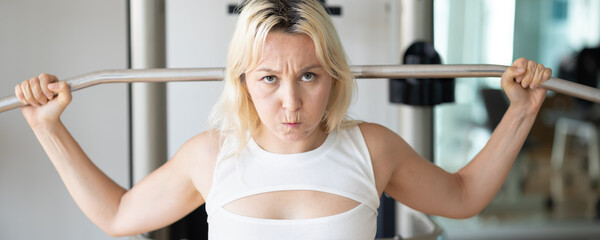 Serious and disciplined fitness woman working out in temperature controlled indoor gym