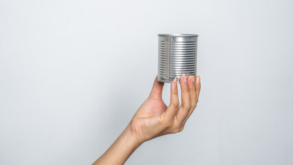 Hand holds canned food isolated on white, woman hands.