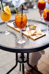 Fresh and iced summer cocktails aperol and snacks on background