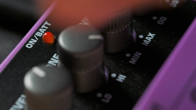 Man adjusting knobs on guitar pedal effect. 4k video footage UHD 3840x2160