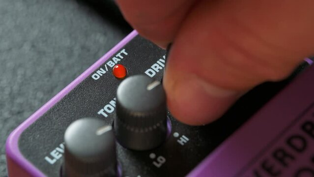 Man adjusting knobs on guitar pedal effect. 4k video footage UHD 3840x2160