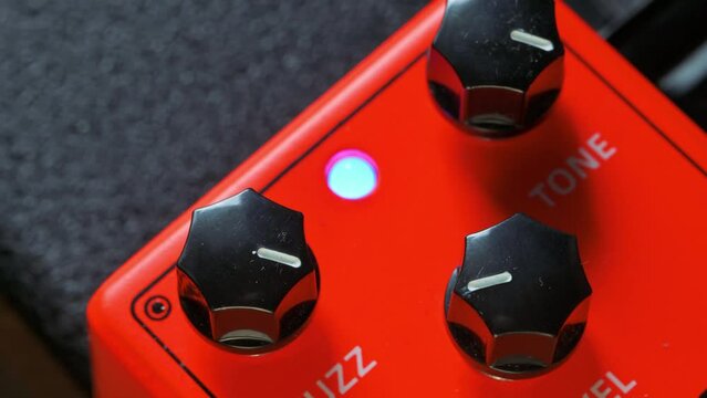 Man tuning knobs on fuzz guitar pedal effect. 4k video footage UHD 3840x2160