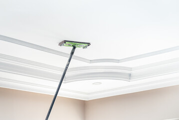 The master sanding the plaster on the ceiling