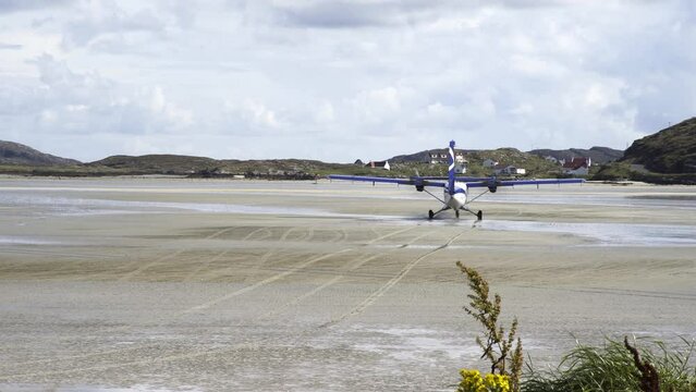 Shot of a plane taxiing along the beach at Barra airport - the worlds only tidal airport using the beach as a runway. The flight was preparing to take off over the incoming tide and ocean.