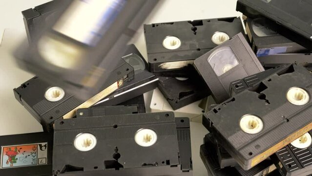 VHS tapes being thrown onto a pile