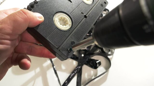Unwinding a VHS cassette with reels and tape inside
