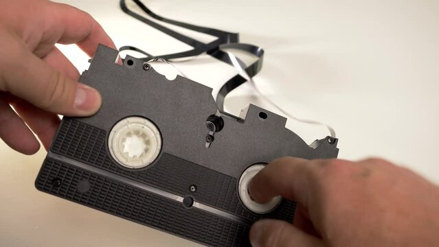Manual rewinding of VHS tape onto the reel in the cassette
