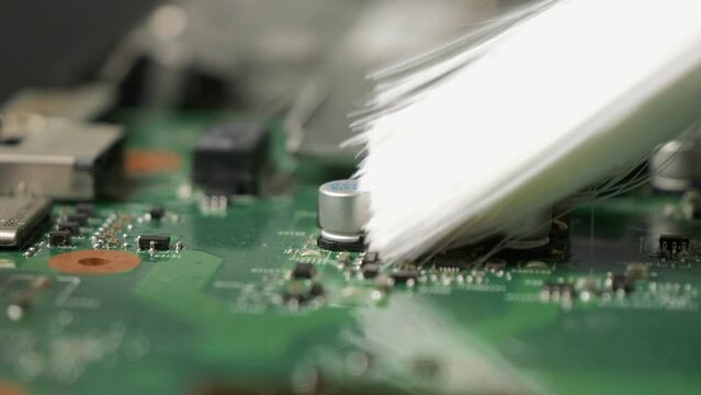 Repair of an old laptop, the technician cleans the dirty interior using a brush