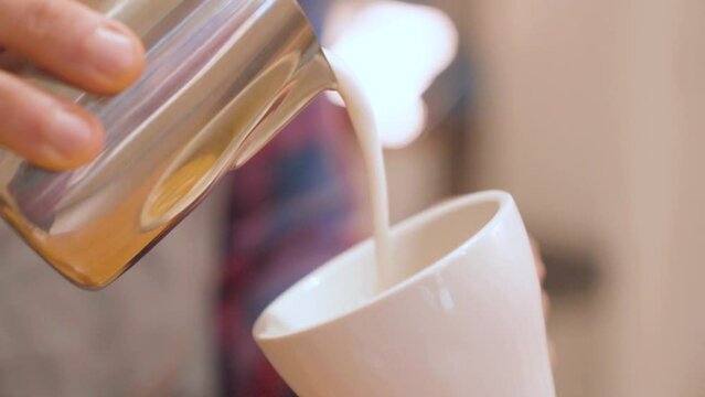 Barista prepares flat white coffee with latte art on surface. Closeup