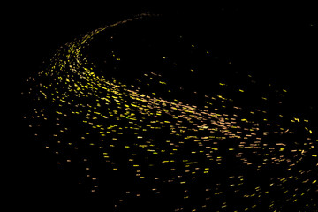 A large number of gold particles converged on the black background