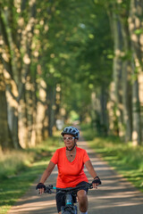 Obraz premium attractive senior woman cycling with her electric mountain bike in the city park of Stuttgart, Baden-Wuerttemberg, Germany