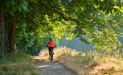 attractive senior woman cycling with her electric mountain bike in the city park of Stuttgart,...