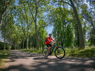 attractive senior woman cycling with her electric mountain bike in the city park of Stuttgart, Baden-Wuerttemberg, Germany