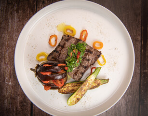 Recipe for grilled steak with chimichurri sauce, accompanied by a farandole of vegetables. High quality photo