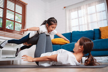 Mother and daughter exercising together happily at home. for flexibility build muscle strength,...