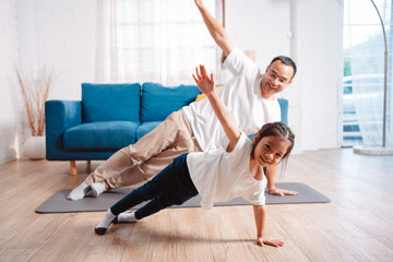 Father and daughter exercising together happily at home. for flexibility build muscle strength,...