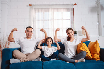 Fototapeta na wymiar Family consisting of parents and daughters happily exercising together at home. For flexibility, build muscle strength, Sport Workout Training family together.