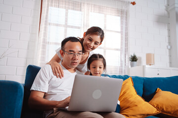 Family parents planing insurance to daughter by laptop computer searching assurance information at home.