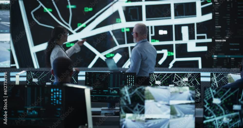 Poster High-Tech Surveillance Office with Multiethnic Specialists Using Satellite Technology to Track a Target Vehicle in Urban Terrain. Large Display Shows Real-Time Monitoring, CCTV Feed and Reports