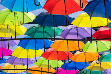 Fototapeta na wymiar 13.06.2023 Białystok Polska. Widok na dekoracyjne kolorowe parasole zawieszone nad ulicą miasta.