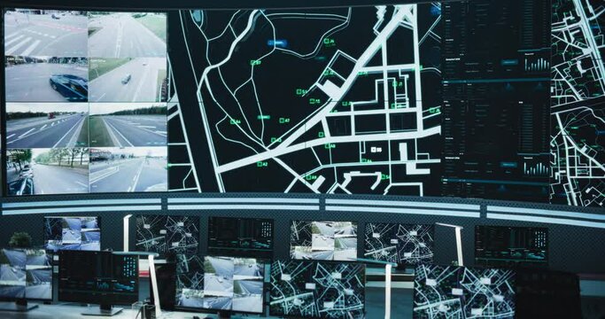 Empty Modern Monitoring Office With Big Digital Screen And Working Places of Employees With Desktop Computers and Displays. Screens Showing a City Map Animation and Surveillance Data