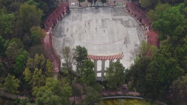 People walking on an skating rink with polluted Mexico City behind them. Aerial tilt up