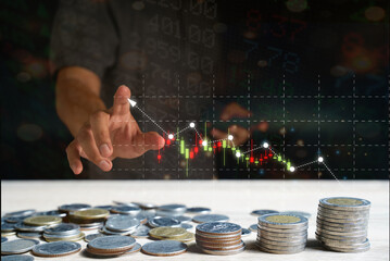 Pile of coins and businessman pointing to growing virtual stock candlestick chart Indicator analysis planning and buy and sell strategy, stock market, business growth, investor stock trading concept.
