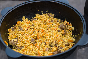 a large cauldron with lamb pilaf, we cook delicious dishes in a cauldron