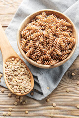 Green lentil fusilli pasta on a old wooden background.