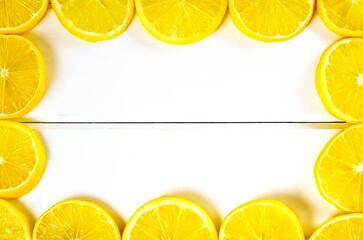 Lemon frame and background. Slices of lemon on a white wooden boards.