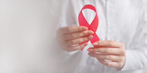 woman doctor hand holding pink ribbon breast cancer awareness in october. concept healthcare and medicine banner with copy space
