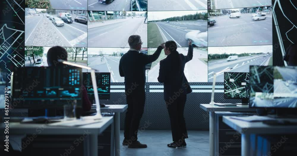 Poster Team of Software Developers, Engineers and Data Scientists Working in a Modern Logistics Technology Company. Male and Female Having a Discussion in Front of a Screen with Surveillance CCTV Footage