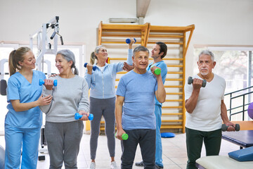 Physiotherapists assisting elderly people exercising at rehabilitation center