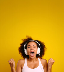 Fototapeta premium Happy, energetic woman listening to music. Isolated on bright yellow background. Banner, copy space.