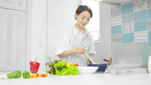 野菜炒めを作る若い女性　料理イメージ	
